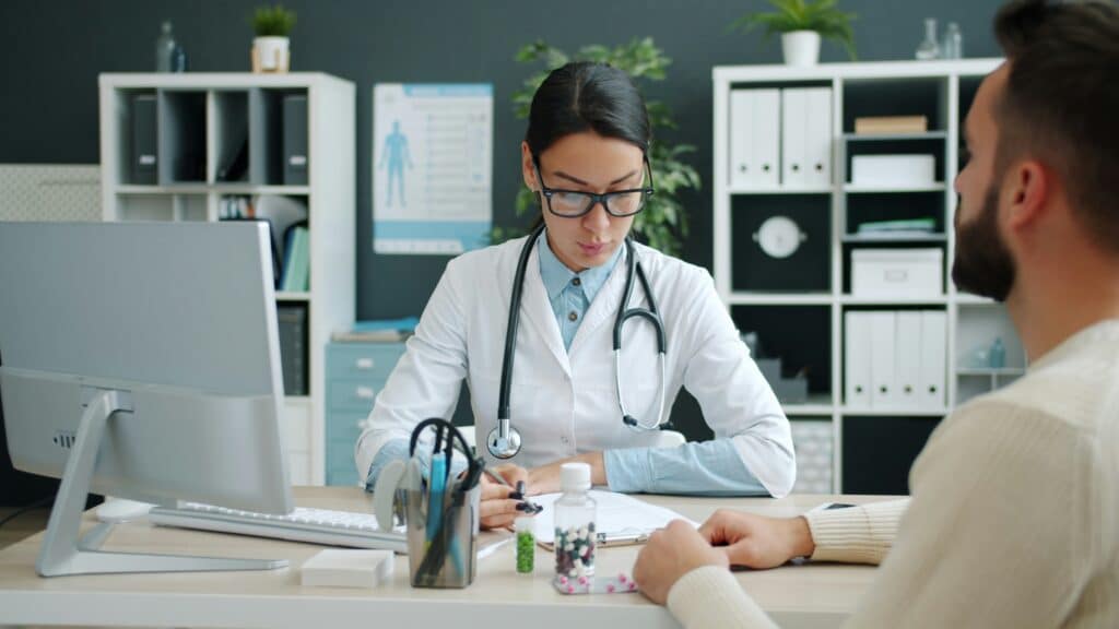 Healthcare professional meeting with a patient in a modern medical office, discussing treatment and care management.